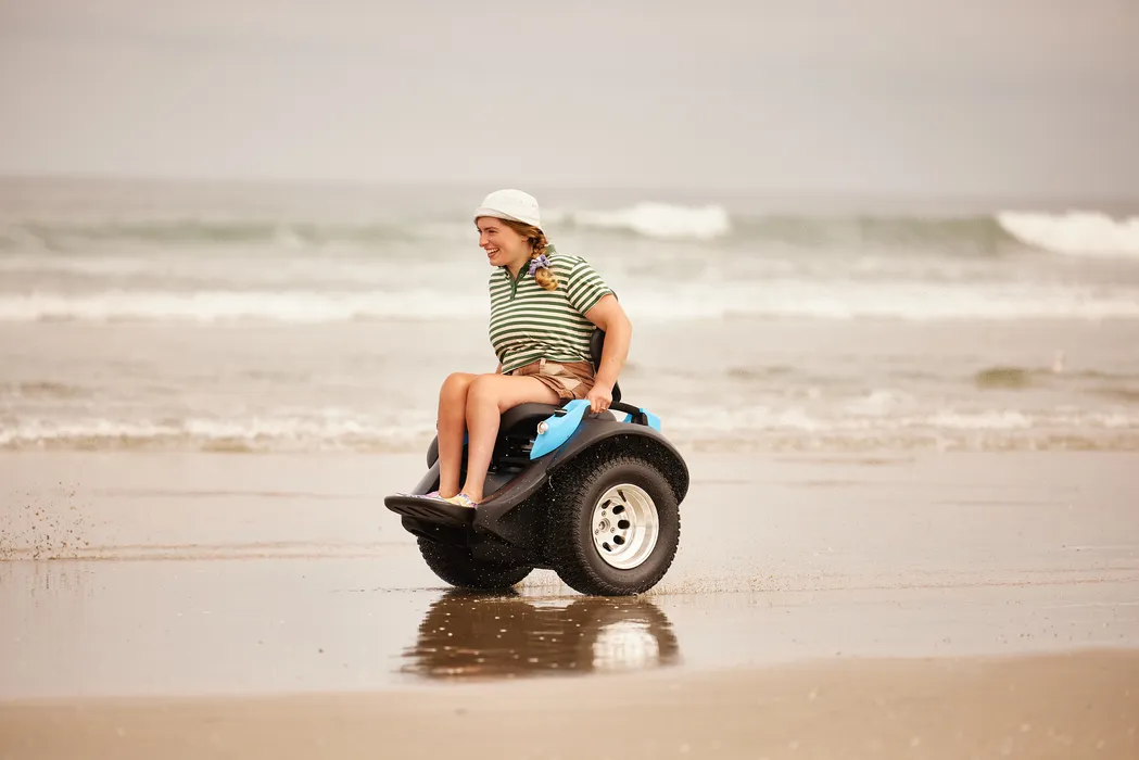 Bild 1: Der Aktivrollstuhl Omeo am Strand: Antrieb und Reifen sind für Sand, Kies, Erde und glatte Oberflächen ausgelegt. (Urheber: Omeo Technology)